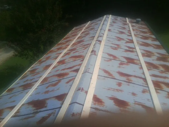 Rusted metal roof panels with new wood purlins before replacement — Storm Damage Roof Repair in Cabazon by Roofing Brothers