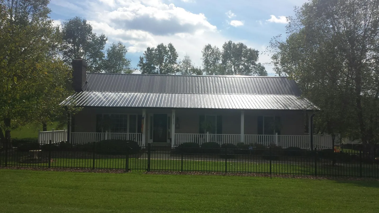 Gray metal roof on a brick ranch with a full width front porch — Gutter Guard Installation work by our crew in Cabazon