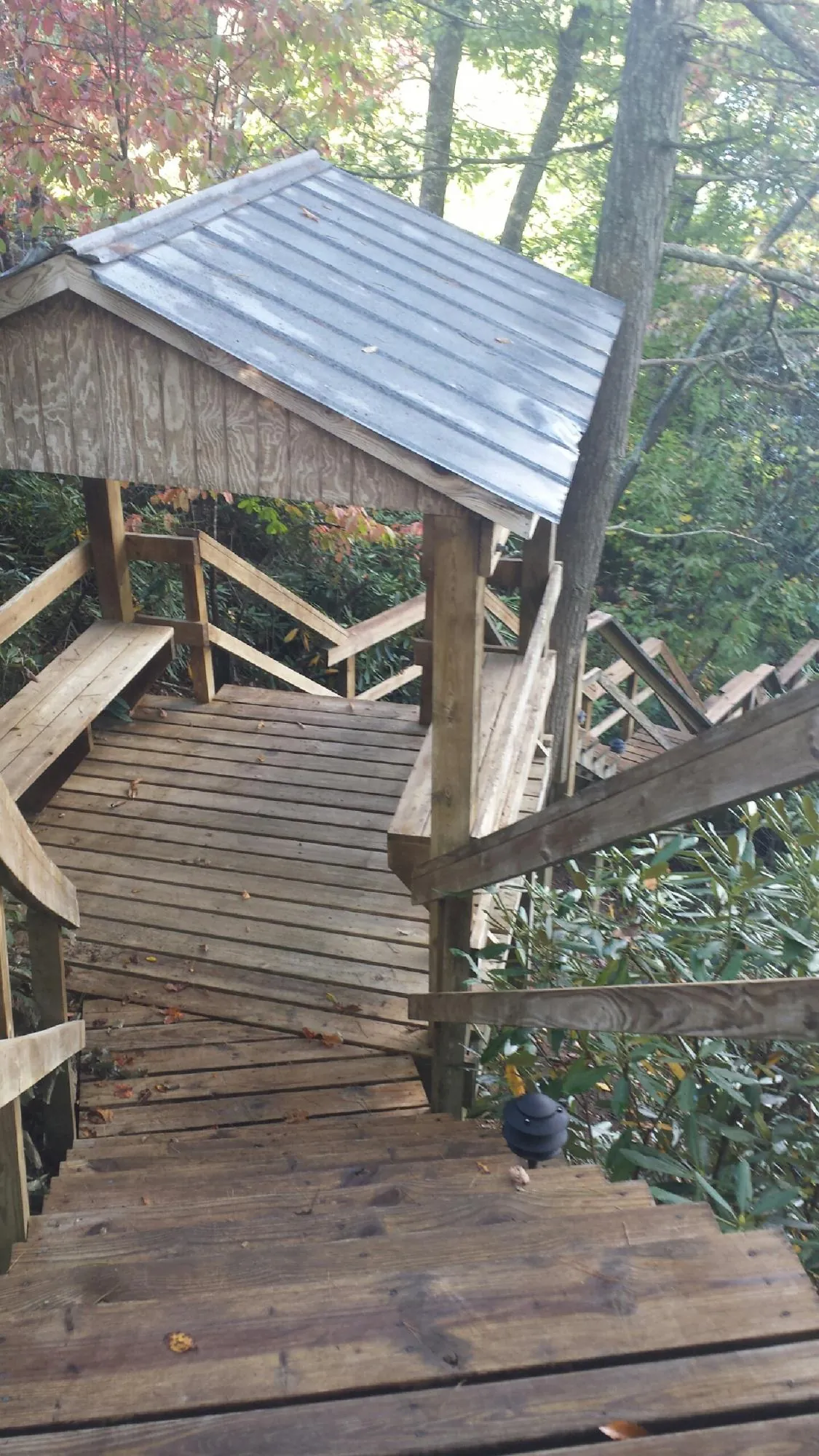 Metal roofed shelter over wooden steps on a wooded walkway — Skylight Repair & Installation work by our crew in Cabazon